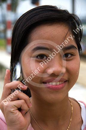 Portrait of a Vietnamese girl using a cell phone in Hue, Vietnam.