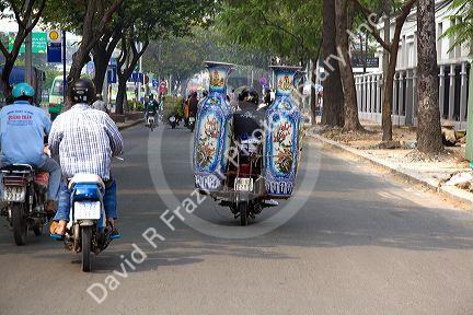 Motorbike hauling large decorative urns in Ho Chi Minh City, Vietnam.