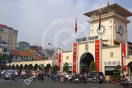 Vietnamese people ride motorbikes in front of the Ben Thanh Market in Ho Chi Minh City, Vietnam.