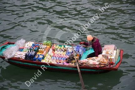 Vendors in boats selling snack food to tourists in Ha Long Bay, Vietnam.