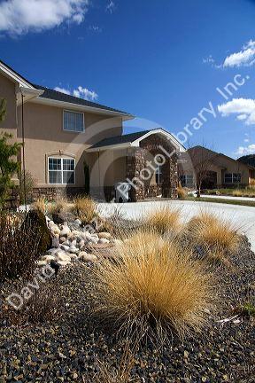 Xeriscaping using rock and native grass to conserve water at a residential home in Boise, Idaho, USA.