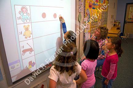 Kindergarten students use an interactive whiteboard in the classroom of a public school in Boise, Idaho, USA. MR