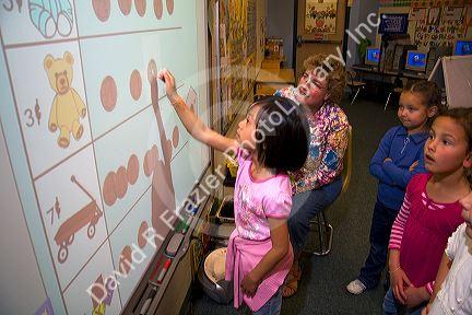 Kindergarten students use an interactive whiteboard in the classroom of a public school in Boise, Idaho, USA. MR