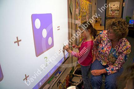 Kindergarten students use an interactive whiteboard in the classroom of a public school in Boise, Idaho, USA. MR