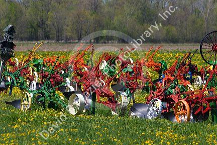 Colorfully painted antique plows on display at a farm near Corunna, Michigan, USA.