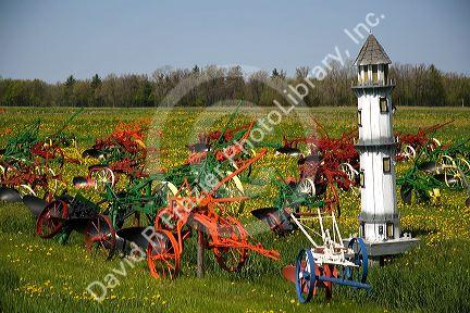 Colorfully painted antique plows on display at a farm near Corunna, Michigan, USA.