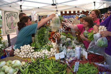 Customers purchase fresh vegetables from a farmers market in Boise, Idaho, USA.