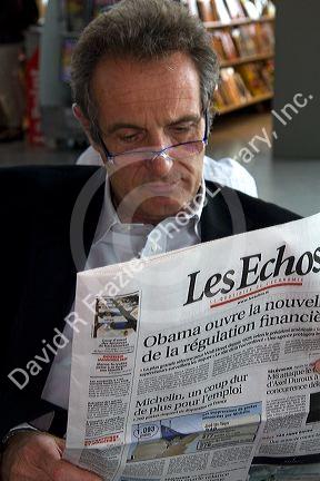 Man reading a french language newspaper in Nice, France.