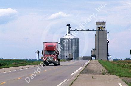 A grain elevator and storage bin and truck traveling on the highway in Mountain Lake, Minnesota.