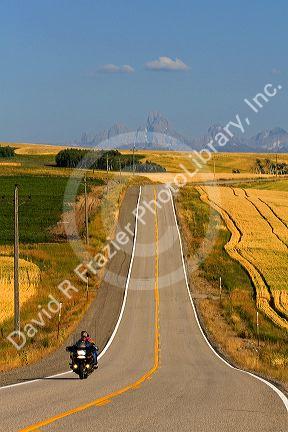 Motorcycling along Idaho Highway 32 with the Teton Range in the distance near Ashton, Idaho, USA.