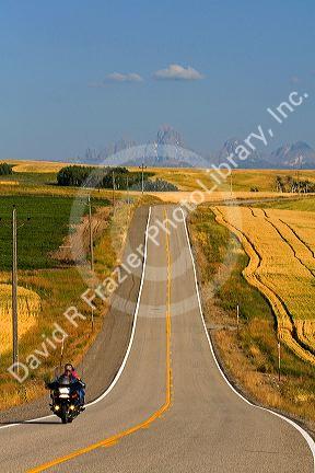 Motorcycling along Idaho Highway 32 with the Teton Range in the distance near Ashton, Idaho, USA.