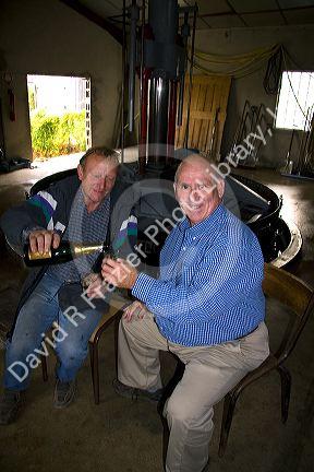 American man drinking Champagne with wine maker near Changy in the region of Champagne-Ardenne, France.