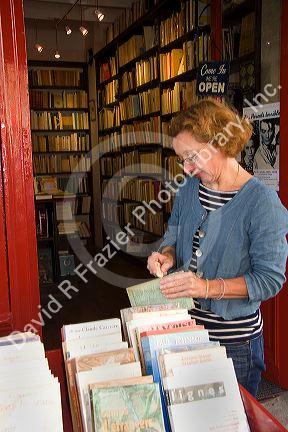 Bookseller cleaning a second-hand book in Paris, France.