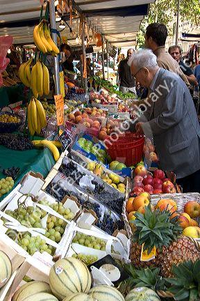 People shopping for produce at an outdoor Saturday market in Paris, France.
