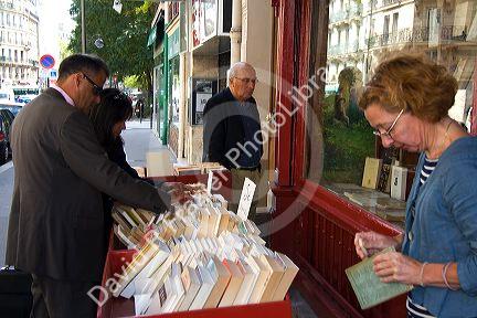 Bookseller cleaning a second-hand book in Paris, France.