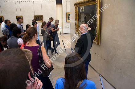 Visitors view artwork displayed in the Musee d'Orsay, Paris, France.