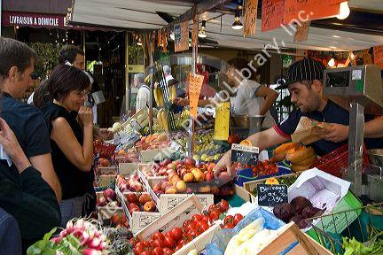 People shopping for produce at an outdoor Saturday market in Paris, France.
