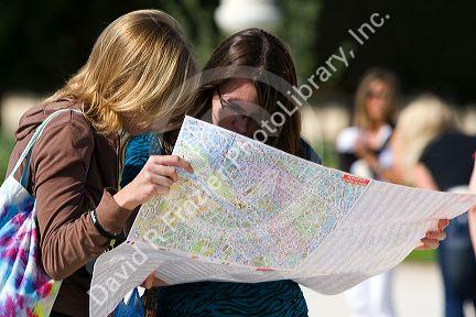 Tourits view a map of Paris at the Tuileries Garden near the Lourve in Paris, France.