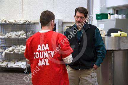 Guard and inmate interact in the day use area of a county jail.