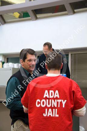 Guard and inmate interact in the day use area of a county jail.