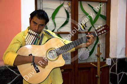Musician playing a traditional panpipe and a guitar in the city of Puebla, Puebla, Mexico.