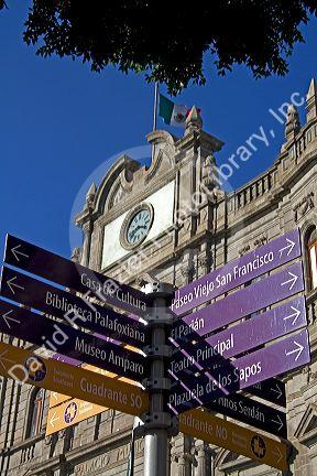 Spanish language street direction signs in front of the Palacio Municipal or City Hall in the city of Puebla, Puebla, Mexico.