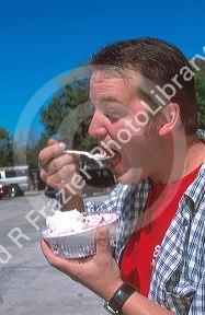 Man eating strawberry shortcake at Parkdale Farms in Plant City, Florida.