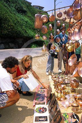 Copper cookware being sold along the roadside in Chile.