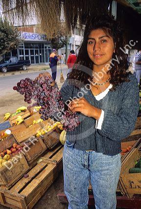 Chilean woman selling grapes at a produce stand in Valparaiso, Chile.