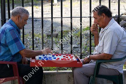Costa Rican men playing a game of checkers on the street in Limon, Costa Rica.