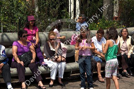 People sit on park benches in the city of San Jose, Costa Rica.