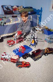 7 year old boy playing with toys in his bedroom. MR