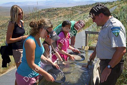 Visitors pan for gold in a demonstration gold panning sluice at the National Historic Oregon Trail Interpretive Center near Baker City, Oregon, USA.