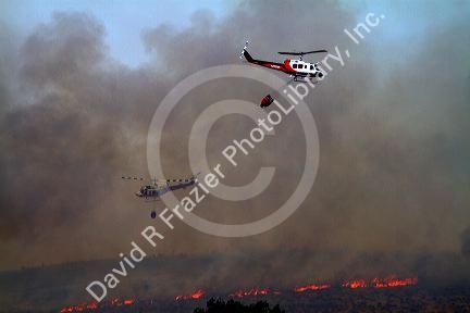 Helicopter with water bucket performing aerial firefighting on a wildfire in Eagle, Idaho, USA.
