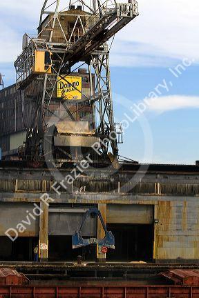 Domino Sugar crane unloads a barge on the Mississippi River at New Orleans, Louisiana, USA.
