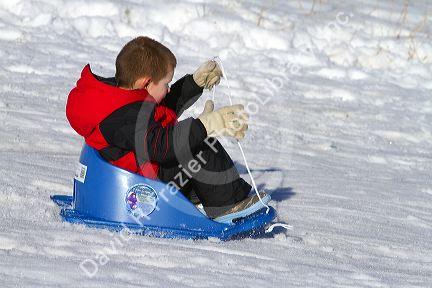 Sledding on a snowy hill near Boise, Idaho, USA.