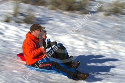 Sledding on a snowy hill near Boise, Idaho, USA.