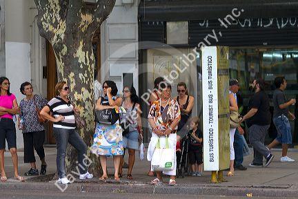 People wait at a bus stop in Buenos Aires, Argentina.