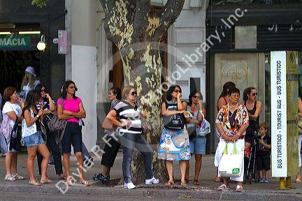People wait at a bus stop in Buenos Aires, Argentina.