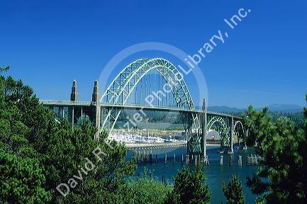 An arched steel bridge with marina in the background in Newport, Oregon.