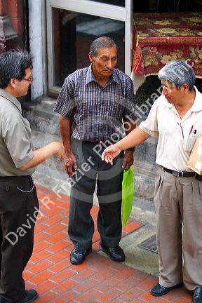 Peruvian men talk on the street in Lima, Peru.