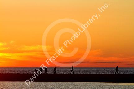 People watch the sunset on Lake Michigan at Pere Marquette Harbor located in Ludington, Michigan, USA.