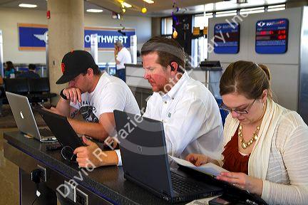 People use wi-fi internet at the Phoenix Sky Harbor International Airport located in the city of Phoenix, Arizona, USA.