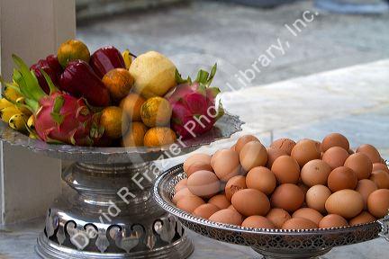 Fruit and egg offerings at the Temple of the Emerald Buddha located within the precincts of the Grand Palace, Bangkok, Thailand.