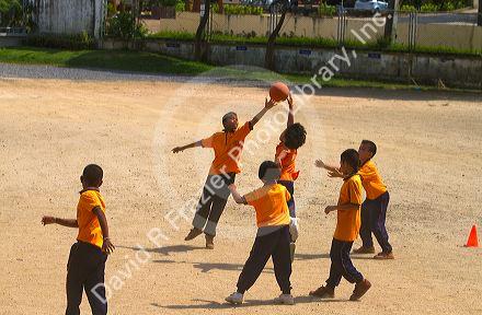 Students play basketball at a Thai elementary school playground on the island of Ko Samui, Thailand.