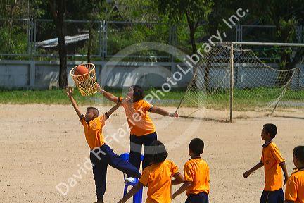 Students play basketball at a Thai elementary school playground on the island of Ko Samui, Thailand.