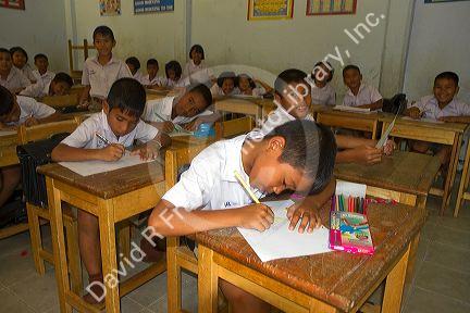 Thai elementary school students sit a desks on the island of Ko Samui, Thailand.