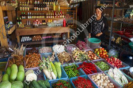 Woman selling fresh vegetables and eggs at an open air market on the island of Ko Samui, Thailand.