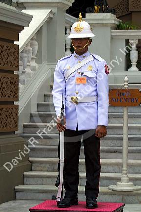 Guard wearing a white uniform at The Grand Palace in Bangkok, Thailand.