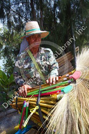 Street vendors selling dried grass brooms on the island of Ko Samui, Thailand.